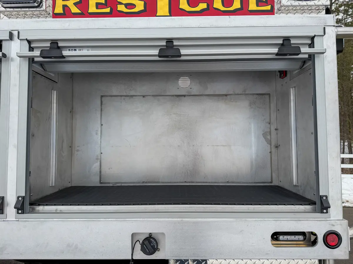 Wide open storage bay with two shelves and interior lighting.